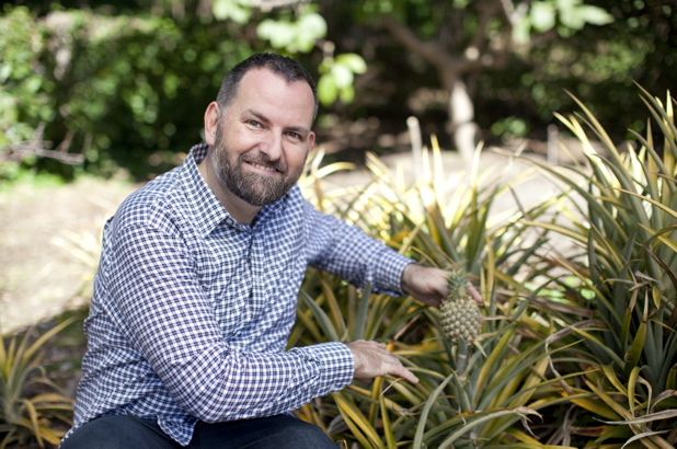 Scott Hill with pineapple in kitchen garden at Vaucluse House