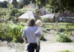 Father carrying son through the kitchen garden.