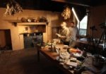 Alysha taking a photo of the Christmas plum pudding in the kitchen at Elizabeth Farm, Scott standing to the side.