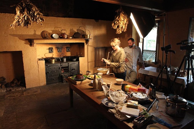 Alysha taking a photo of the Christmas plum pudding in the kitchen at Elizabeth Farm, Scott standing to the side.