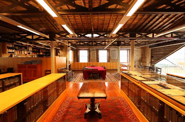 Image of the interior of the library looking toward windows. Collection storage cabinets are visible on the left and right of the frame.