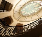 View looking up at the saloon dome which is the centre piece of EBH. The dome appears to be 3 stories above the camera. Openings looking into the saloon and a spiral staircase that follows the exterior of the saloon are visable.