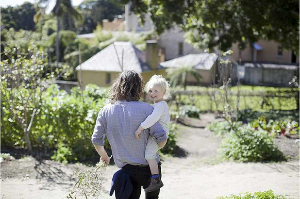 Father carrying son through the kitchen garden.