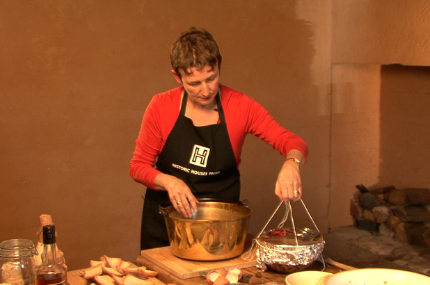 Jacqui holding up the pudding with string and foil in place, ready to go in the saucepan.