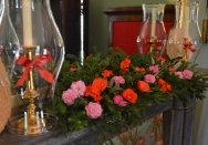 An arrangement of flowers, greenery and candle shades on the chimneypiece at Elizabeth Farm.