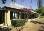 Exterior of Elizabeth Farm, showing the verandah and Bougainvillea in bloom.