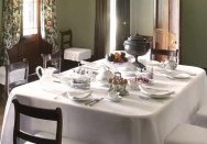 The Elizabeth Farm dining table set for breakfast with eggs, fruit and tea visible on the table.