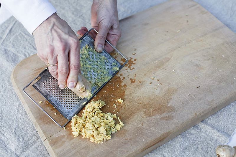 Grating ginger on a wooden board, to make ginger beer.