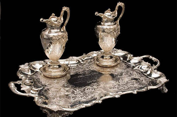 Two silver claret jugs, two silver coasters and a silver presentation tray.