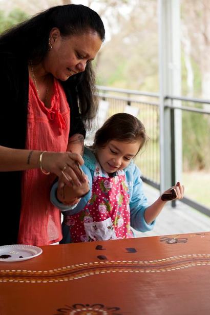 Leanne Watson local Darug woman and chairperson of the Darug Custodians Aboriginal Corporation demonstrates painting techniques to Isabella Redpath