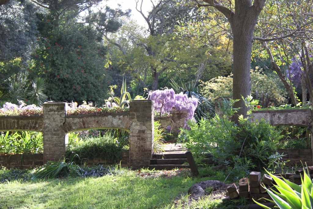 Photograph of brick arches in a garden setting